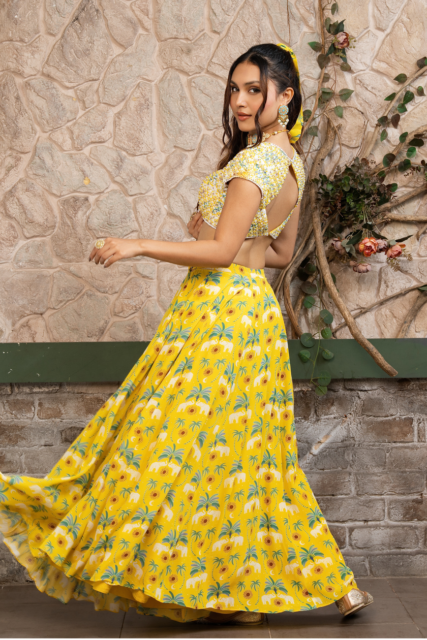Woman wearing a yellow printed lehenga set with a hand-embroidered blouse and embroidered tulle dupatta in Senren's signature  bohemian print.