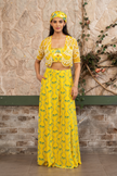 Woman wearing a yellow printed bustier with flowing sharara pants and a hand-embroidered cape in Senren's signature bohemian print.