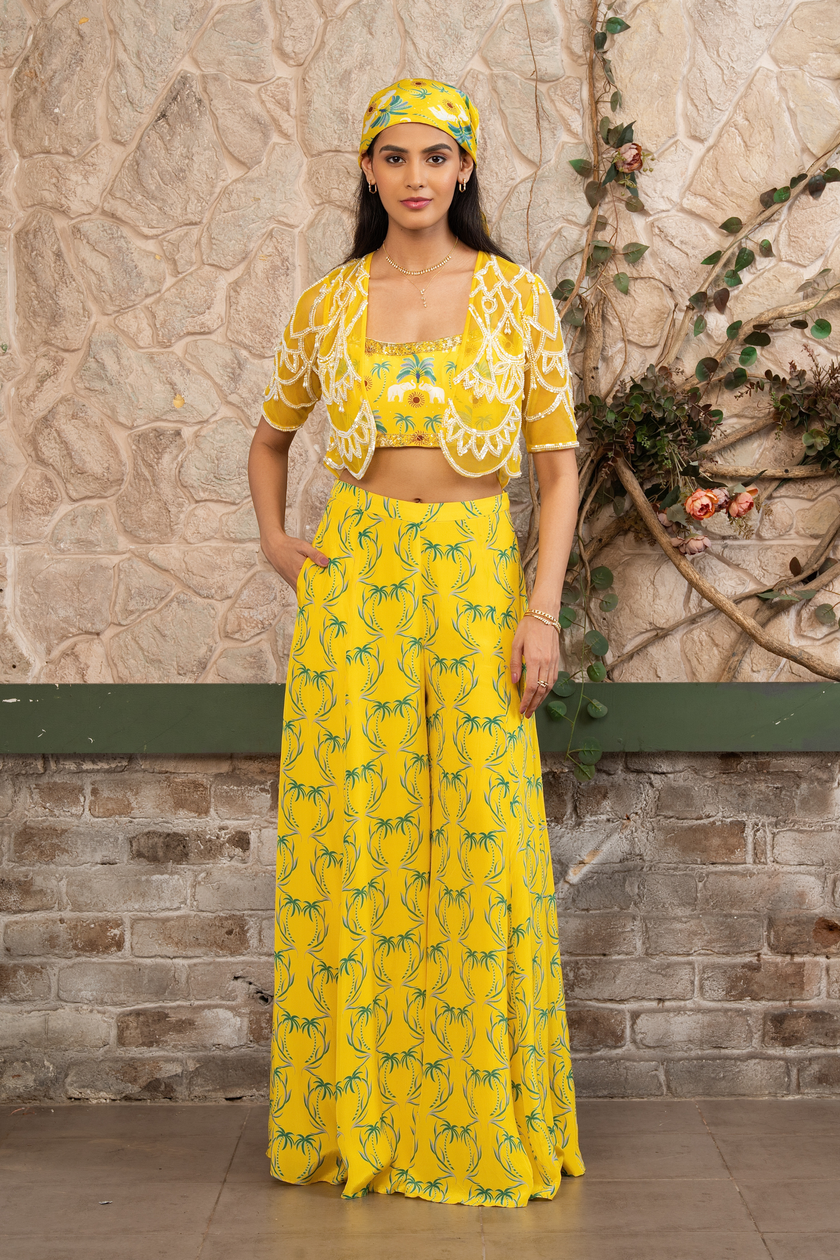 Woman wearing a yellow printed bustier with flowing sharara pants and a hand-embroidered cape in Senren's signature bohemian print.