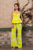 Woman wearing a lime green floral printed corset peplum co-ord set with wide-leg trousers