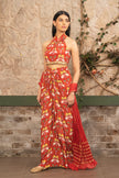Woman wearing a hand-embroidered  red boho printed halter neck co-ord set with draped skirt and a textured dupatta featuring tropical and elephant motifs by Senren.