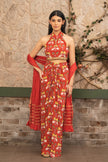 Woman wearing a red boho printed halter neck co-ord set with draped skirt and a textured dupatta featuring tropical and elephant motifs by Senren.