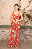 Woman wearing a red printed sleeveless peplum co-ord set with flared trousers in Senren's signature bohemian print.