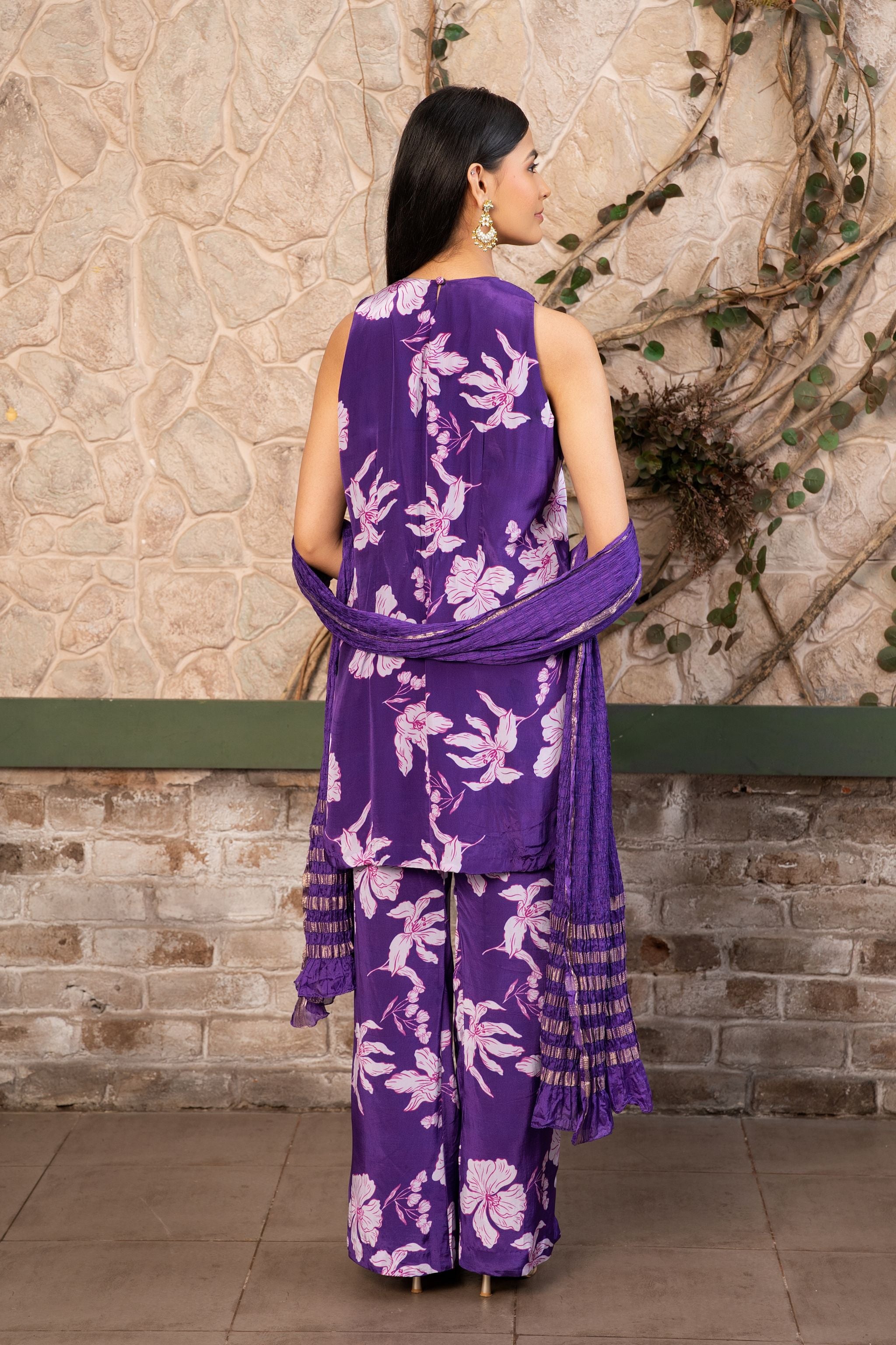 Woman wearing a purple floral printed kurta set with a hand-embroidered yoke, wide-leg  pants, and a satin dupatta by Senren.