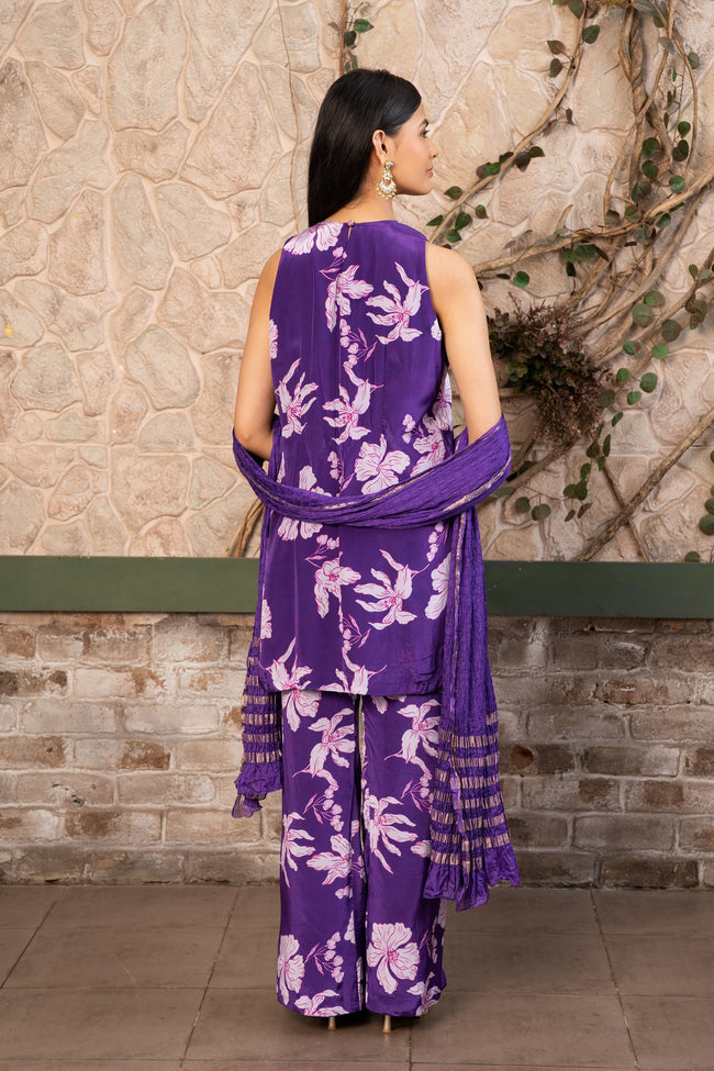 Woman wearing a purple floral printed kurta set with a hand-embroidered yoke, wide-leg  pants, and a satin dupatta by Senren.