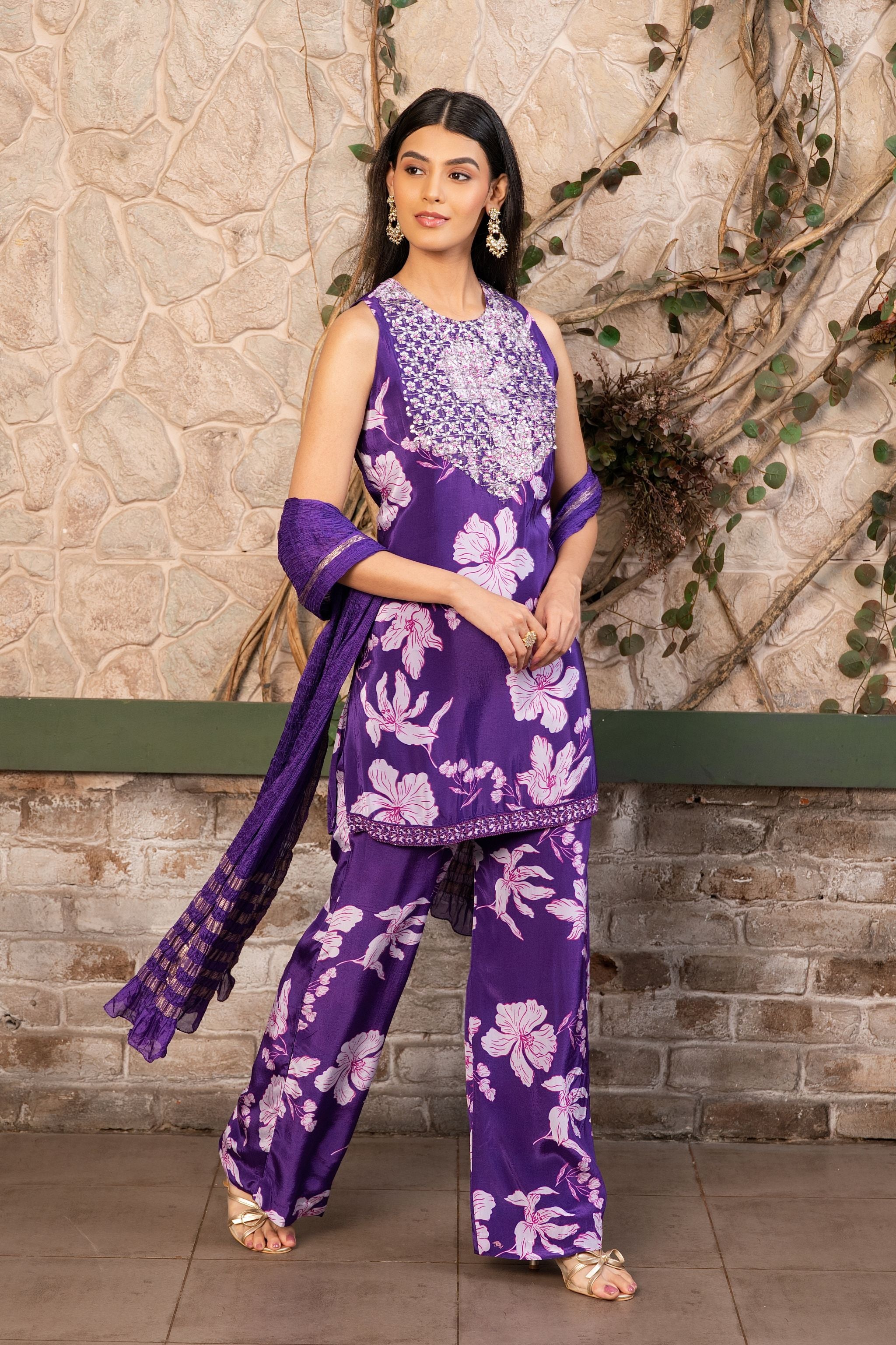 Woman wearing a purple floral printed kurta set with a hand-embroidered yoke, wide-leg  pants, and a satin dupatta by Senren.