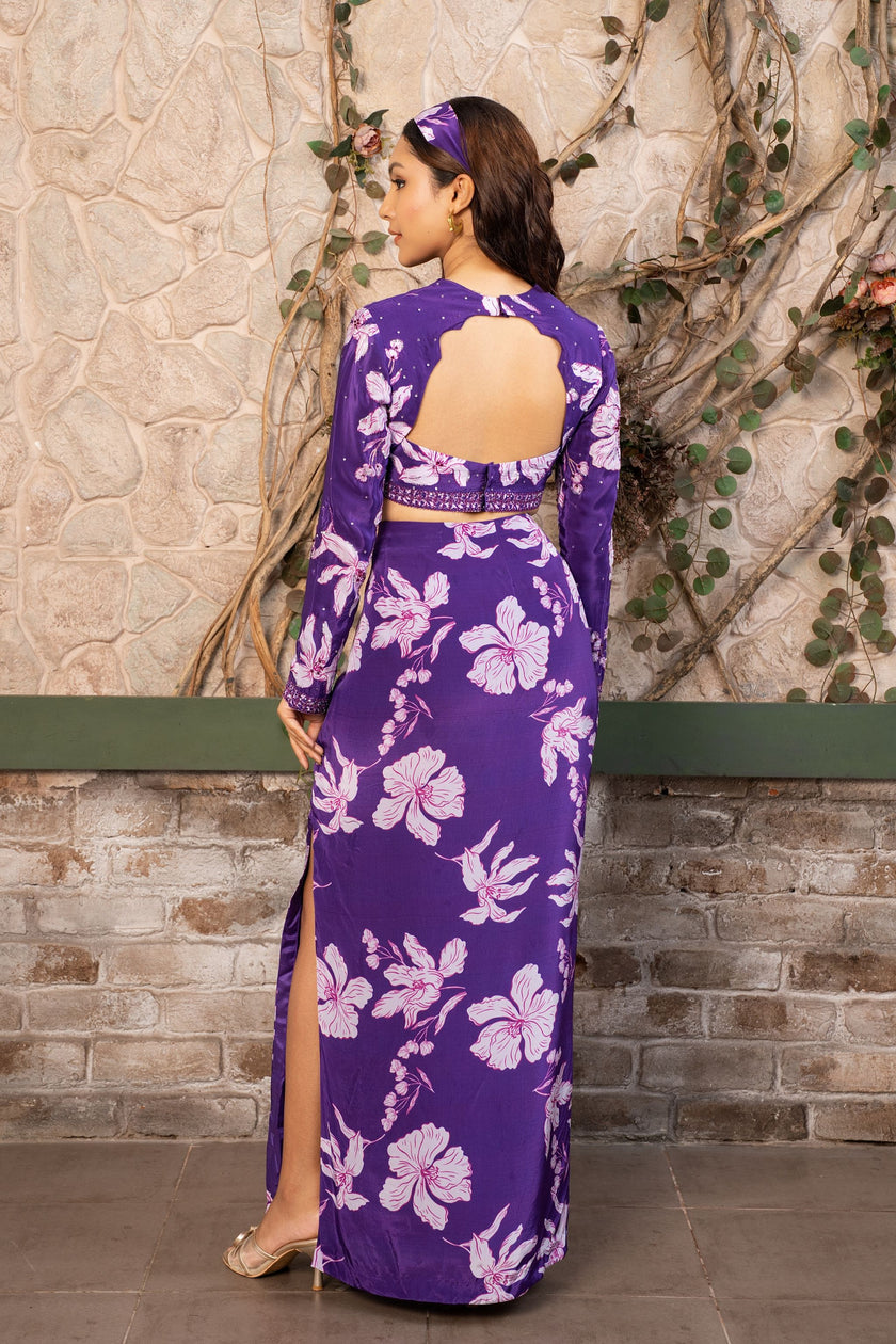 Woman wearing a violet floral printed crop top blouse with a matching high-waisted side slit skirt, luxury Indo-Western designer outfit by Senren.