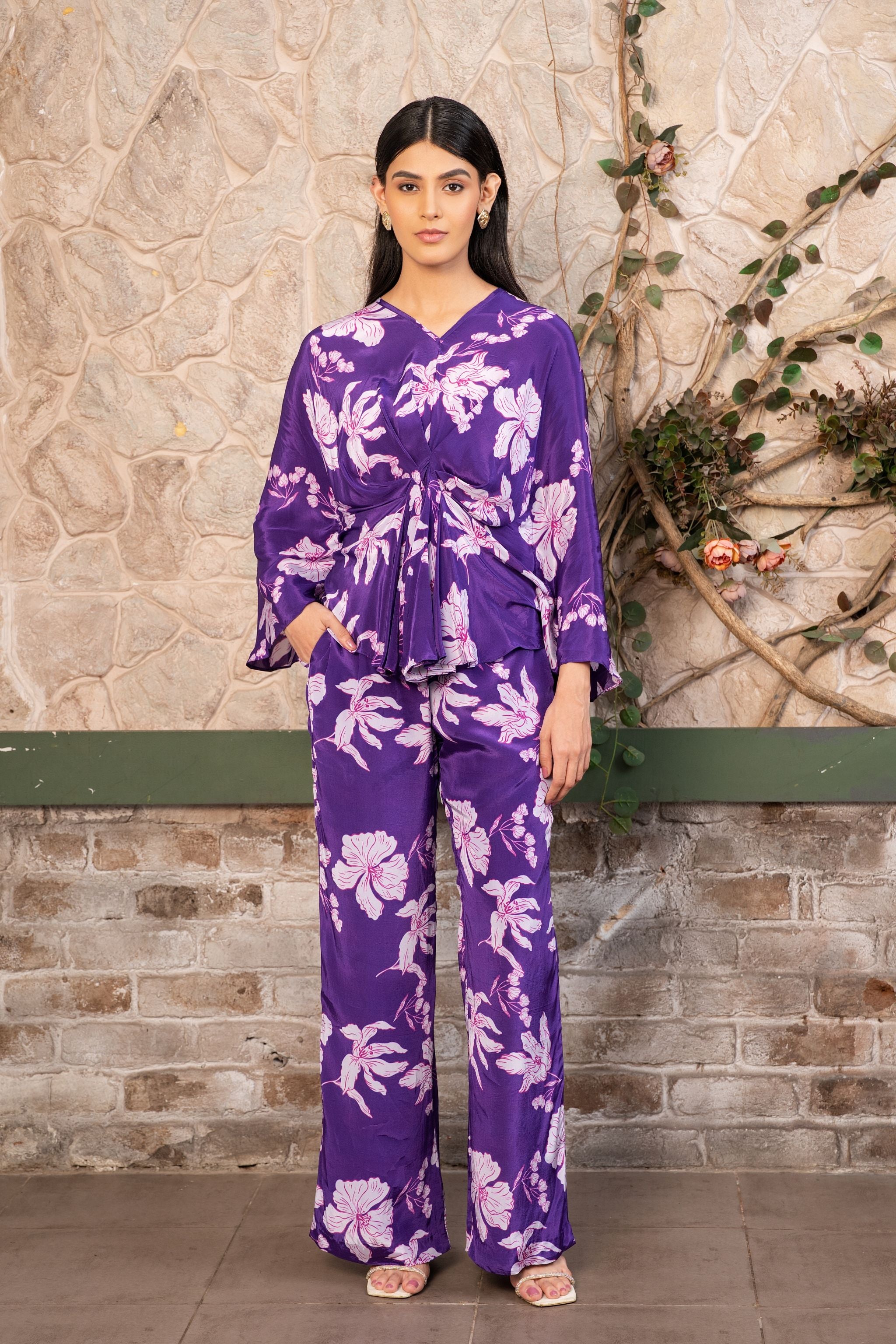 Woman wearing a violet floral printed pleated top with matching pants, luxury designer co-ord set for women by Senren.