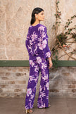 Woman wearing a violet floral printed pleated top with matching pants, luxury designer co-ord set for women by Senren.