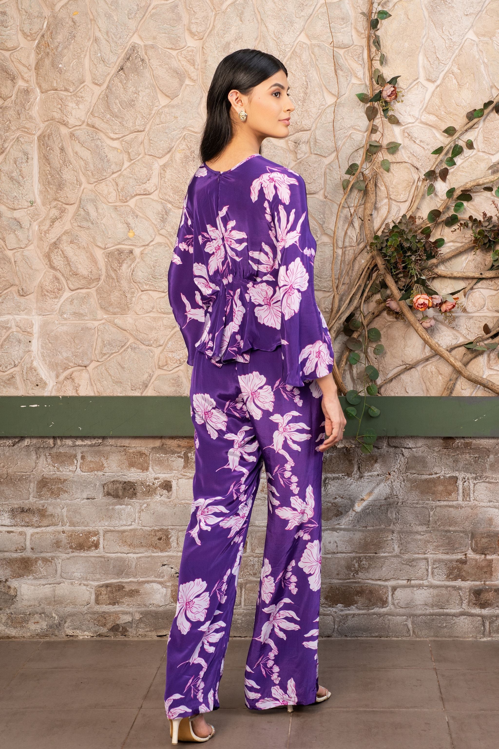 Woman wearing a violet floral printed pleated top with matching pants, luxury designer co-ord set for women by Senren.