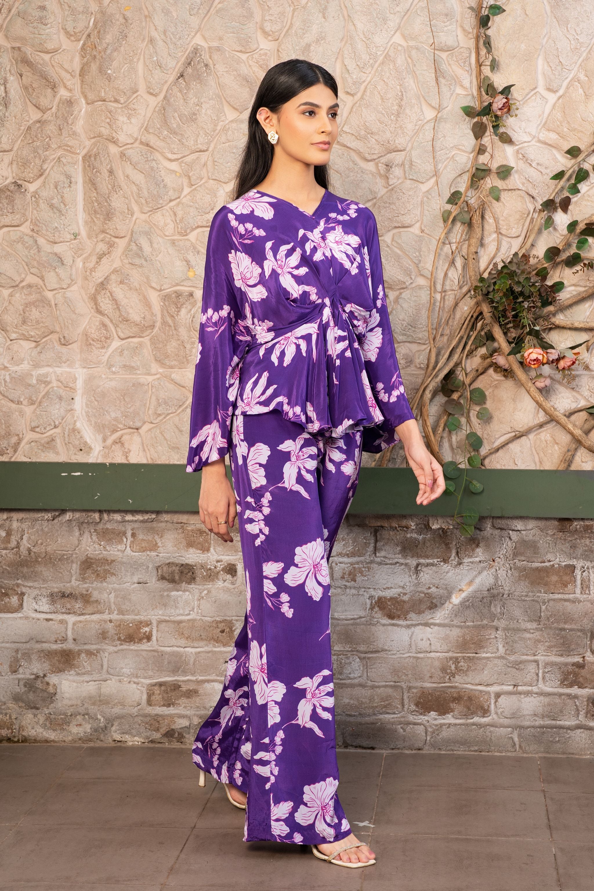 Woman wearing a violet floral printed pleated top with matching pants, luxury designer co-ord set for women by Senren.